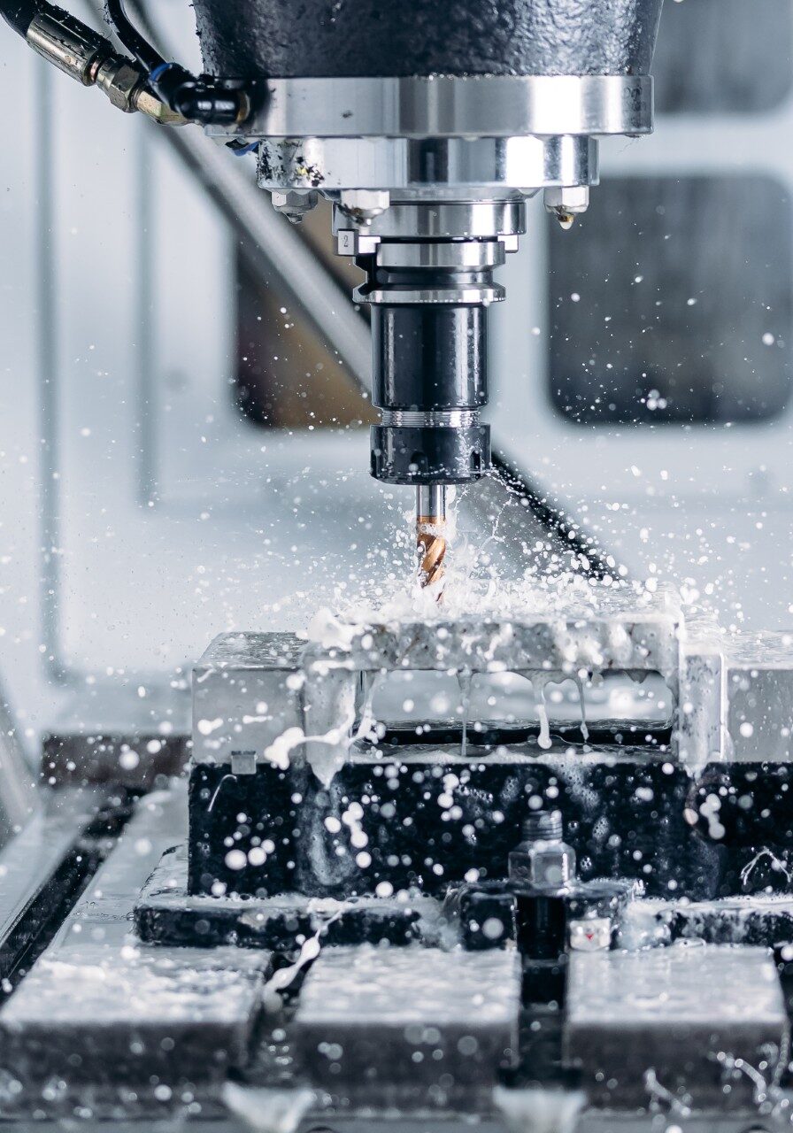 CNC milling machine cutting metal with coolant spray